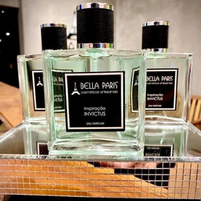 Três frascos do Perfume Masculino Inspiração Invictus expostos na loja Bella Paris, destacando a presença imponente do perfume no ambiente de venda.